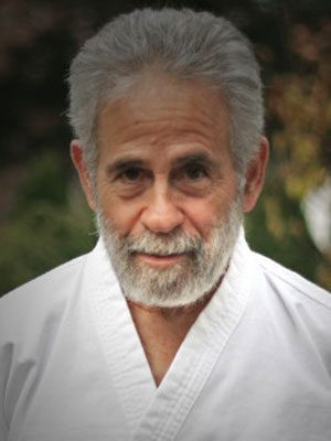 Paul Linden, An older man with short grey hair and a full beard wearing a martial arts outfit.